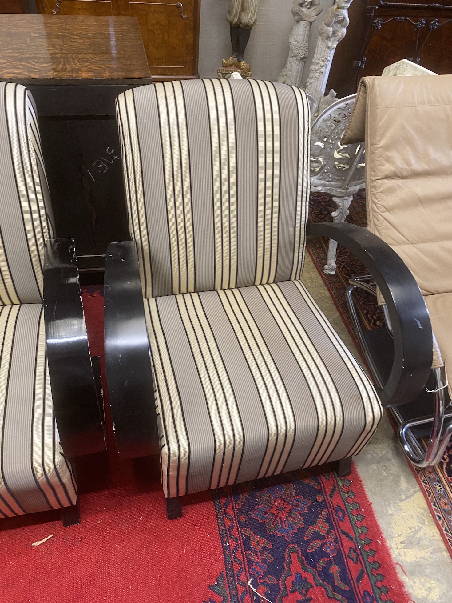 A pair of Deco style ebonised upholstered armchairs, width 78cm, depth 92cm, height 87cm